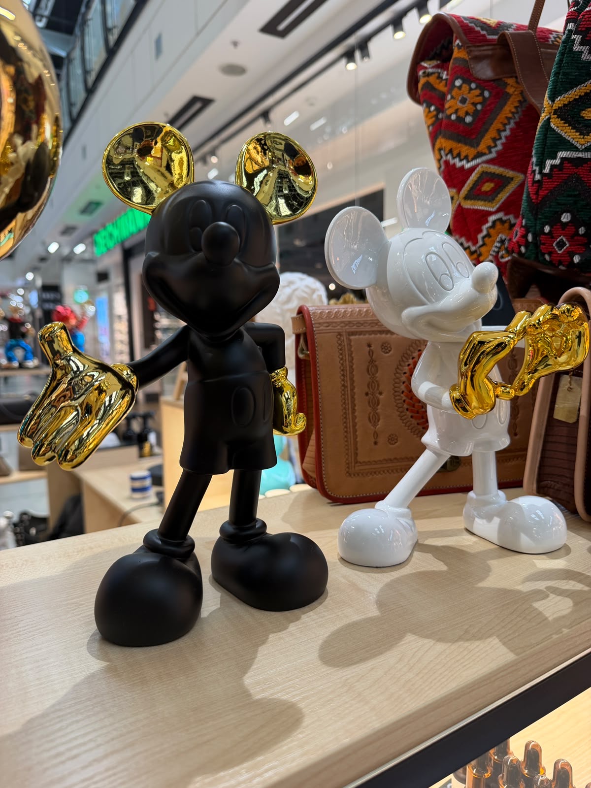 Black and white mouse sculptures with gold hands